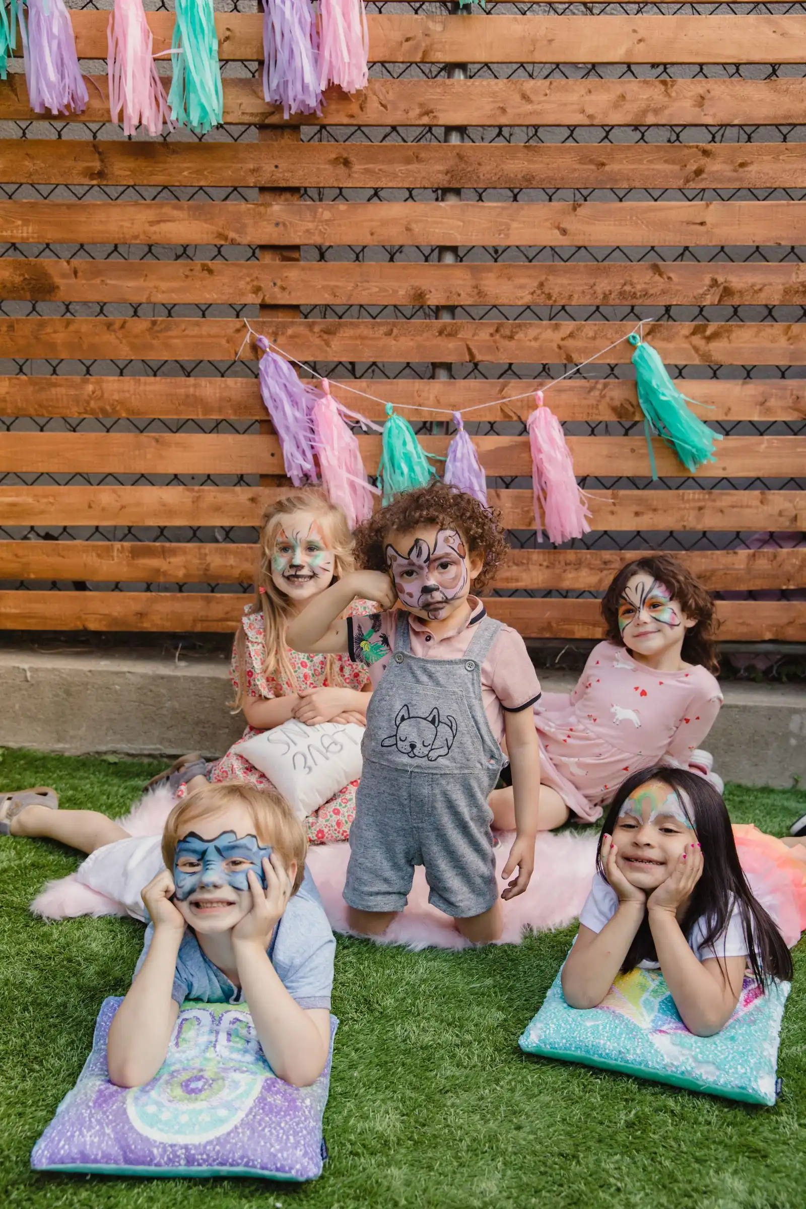 Group of children with painted faces at an outdoor birthday party