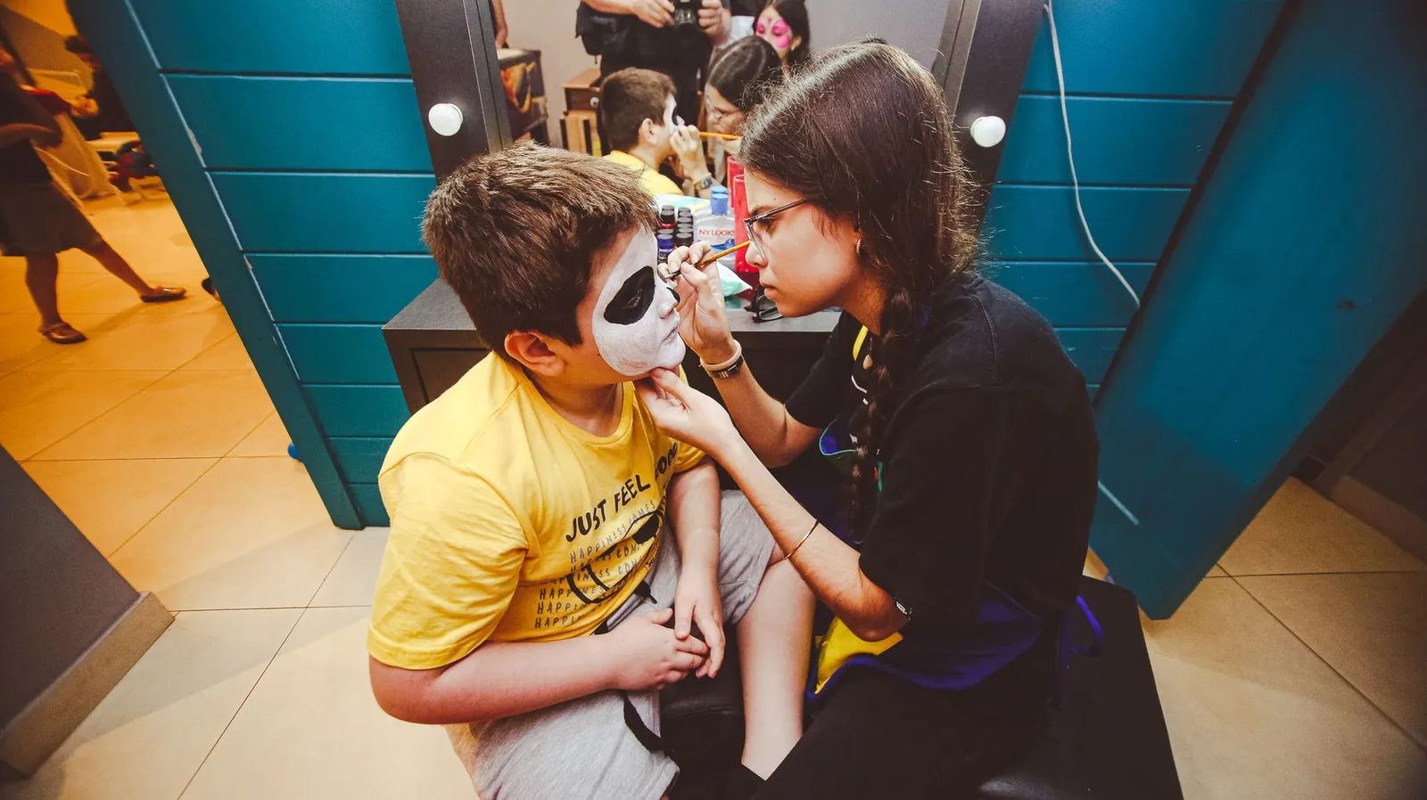 A face painter carefully painting a child's face